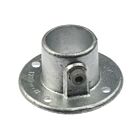 Silver hot-dip galvanised cast iron wall flange with a circular base, mounting holes, and a pipe socket set screw.