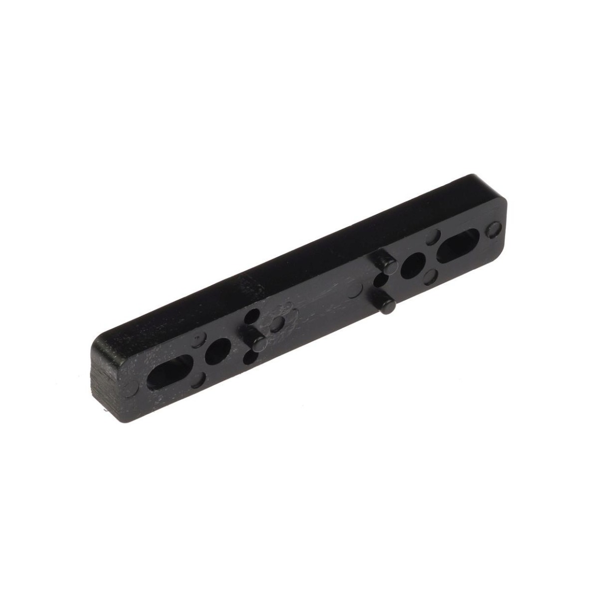 An elongated black plastic shim featuring several mounting holes and small alignment pins, used as a spacer for industrial equipment.
